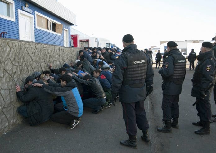 russian-police-detain-migrants-696x493